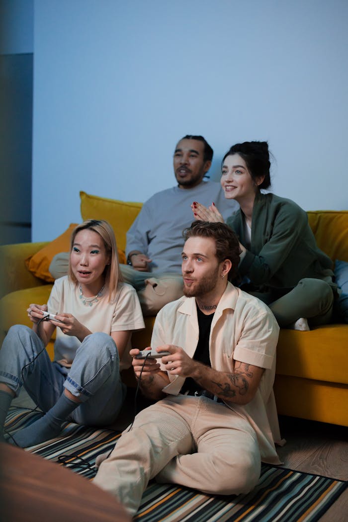 Four friends having fun and playing video games together indoors.